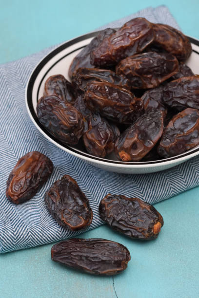 Dried medjool date fruit isolated on weathered wooden background.
